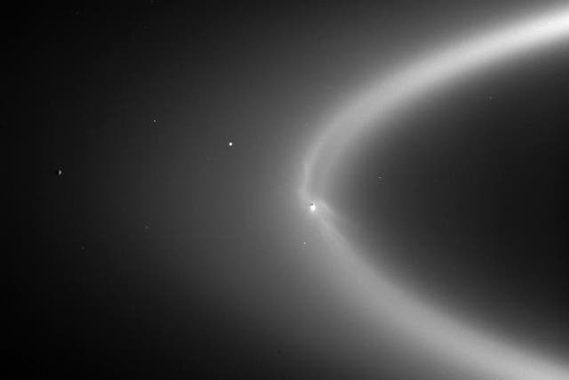 <p>NASA image of Enceladus within the E-ring in orbit around Saturn</p>