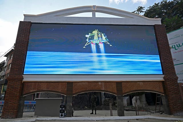 <p>An Indian paramilitary trooper stands guard as a live telecast is aired near a clock tower in Srinagar on August 23, 2023, showing the Chandrayaan-3 spacecraft minutes before its successful lunar landing on the south pole of the Moon</p>