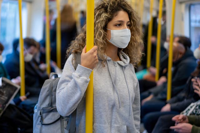 <p>Stock photo of woman wearing a facemask on public transport </p>